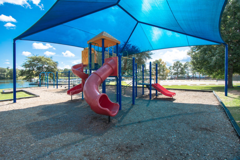Photo of playground with slides, tent and swings.
